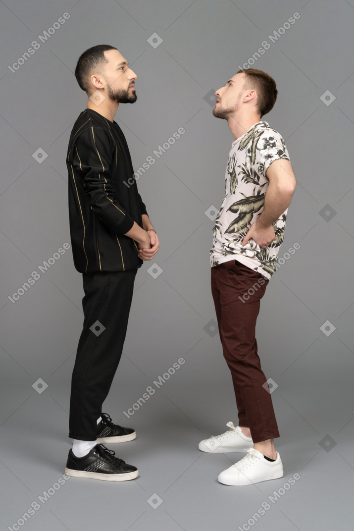 Side view of two young men looking up thoughtfully