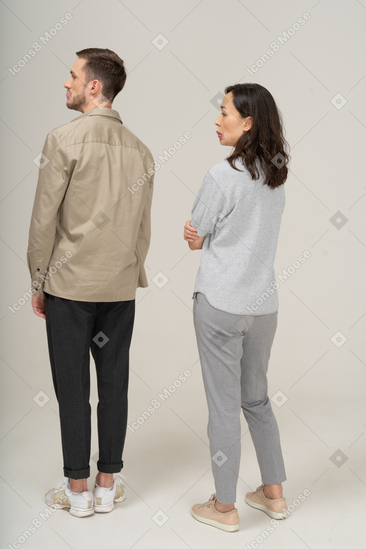 Three-quarter back view of young couple pouting