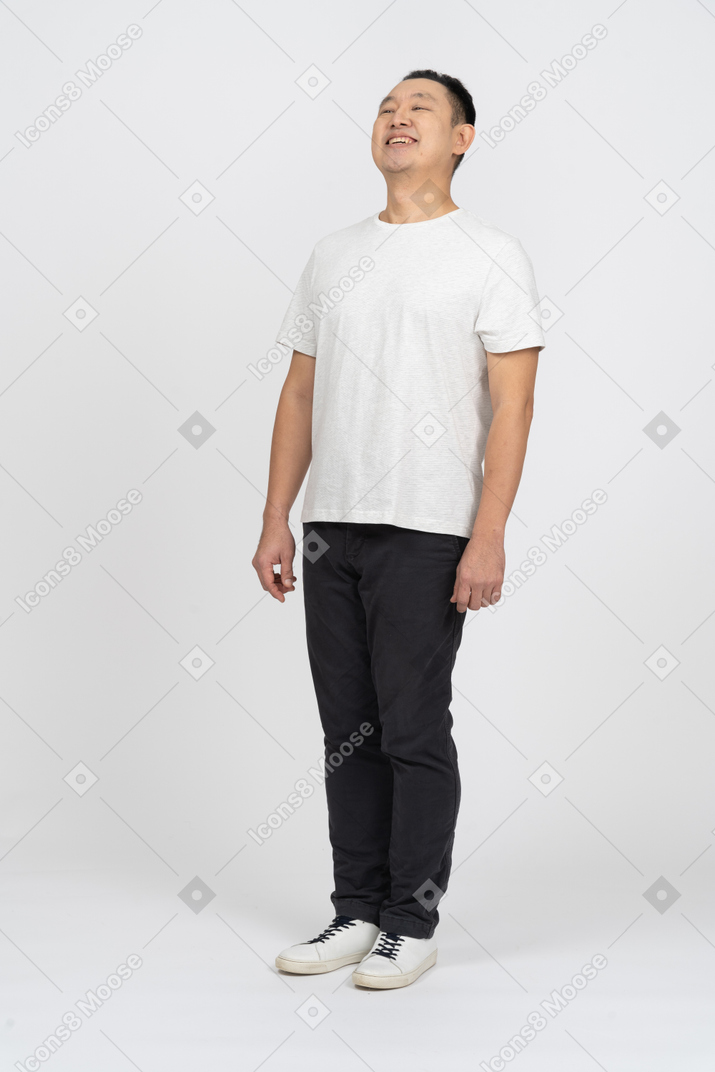 Front view of a happy man in casual clothes looking up