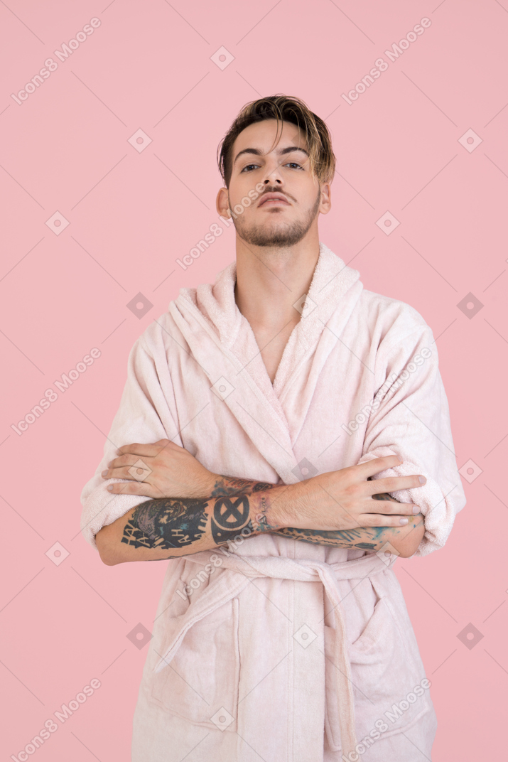 Handsome guy in pink robe standing with his hands in pockets