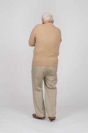 Rear view of a scared old man in casual clothes