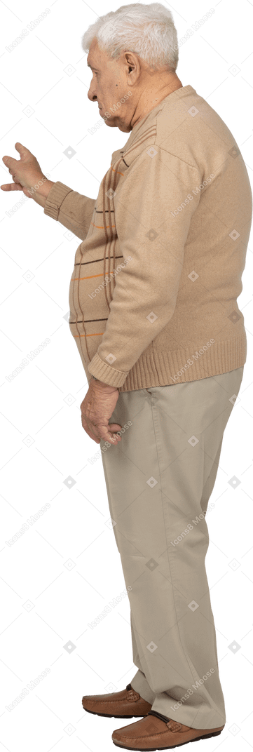 一位穿着休闲服的老人用手指指着的侧视图