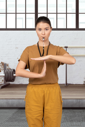 A coach making a timeout gesture in gym