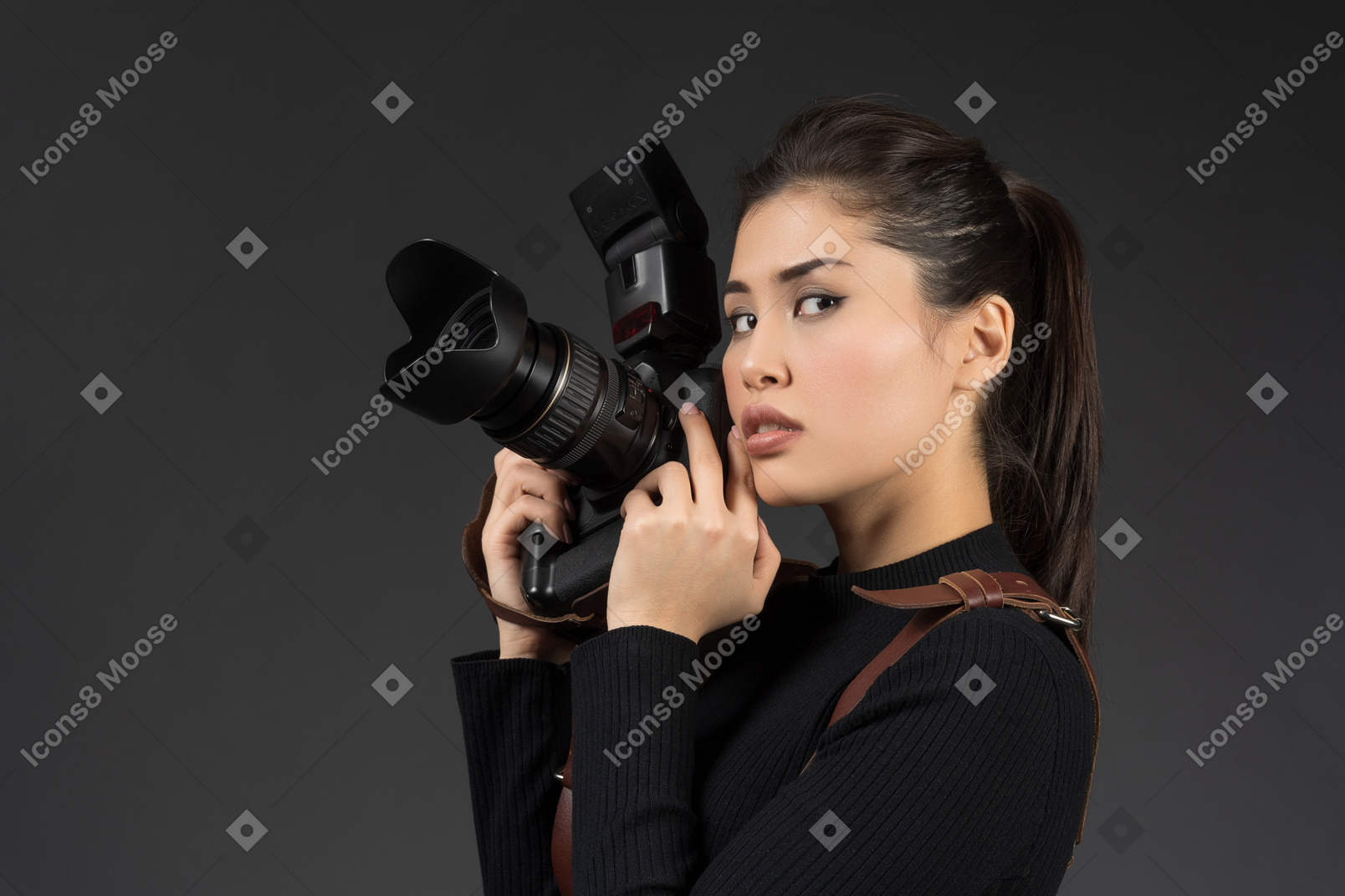 Young woman holding camera and posing for a photo