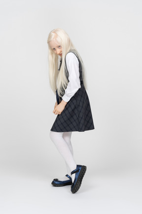 Schoolgirl looking over shoulder with a sly expression
