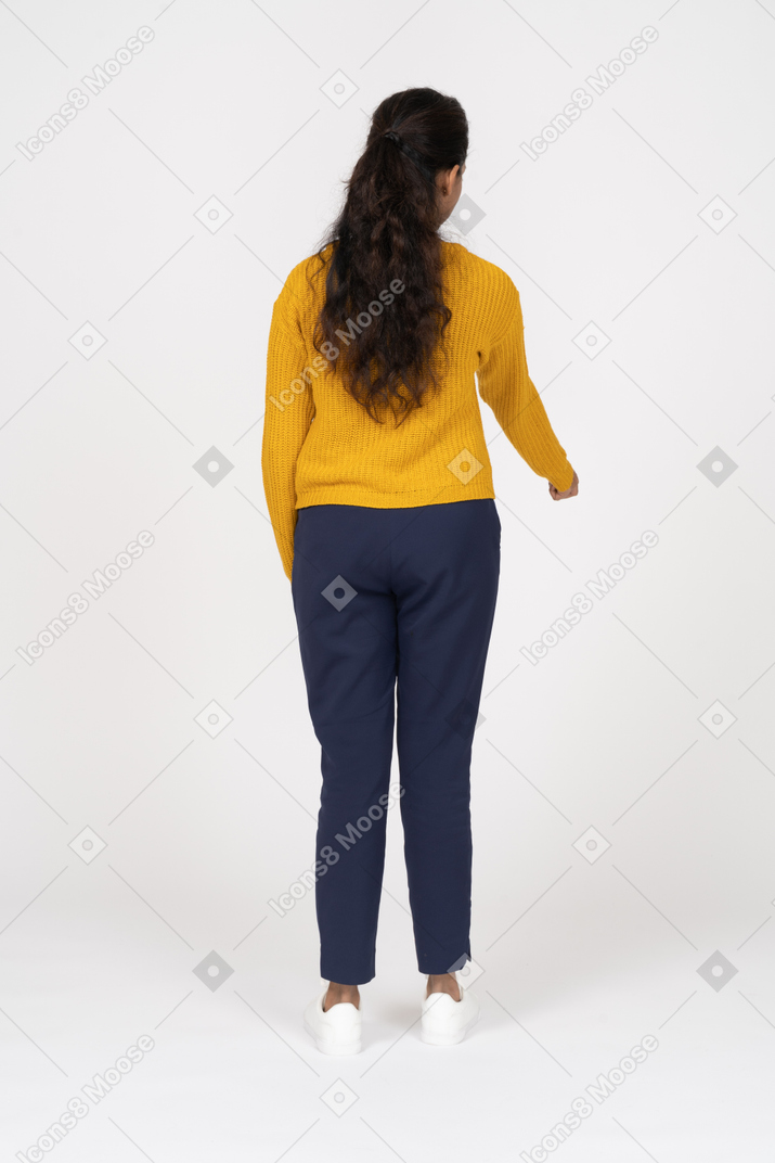 Back view of a girl in casual clothes pointing at something