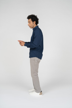 Vista lateral de um homem com roupas casuais gesticulando