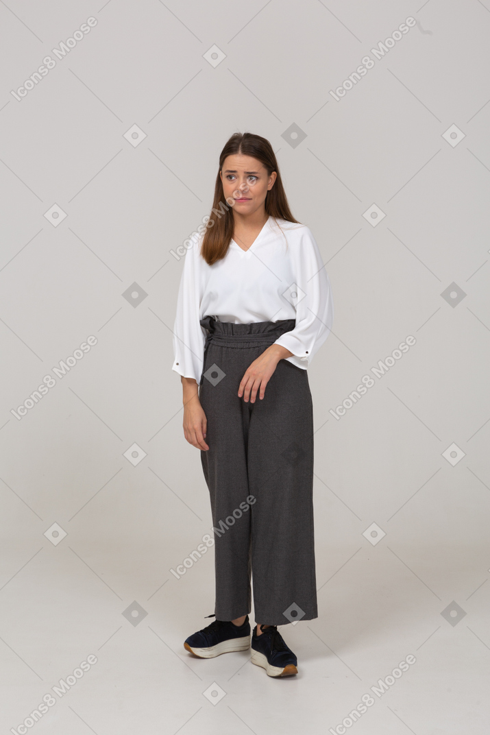 一位身着办公室服装的心烦意乱的年轻女士的前视图，望向一边