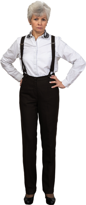 Full-length of an old  perplexed female in suspenders putting hands on hips