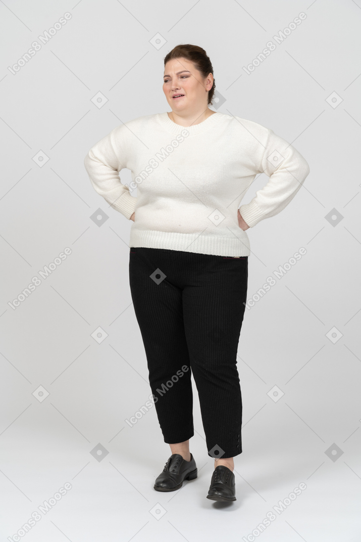 Donna grassoccia in abiti casual in piedi con le mani sui fianchi