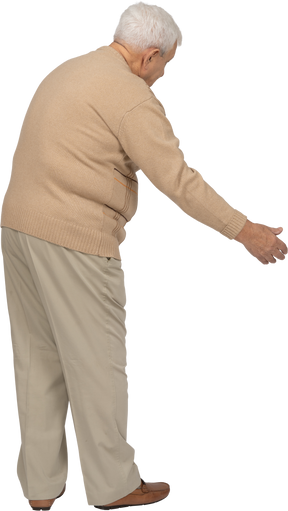 一位穿着休闲服的老人做欢迎手势的侧视图