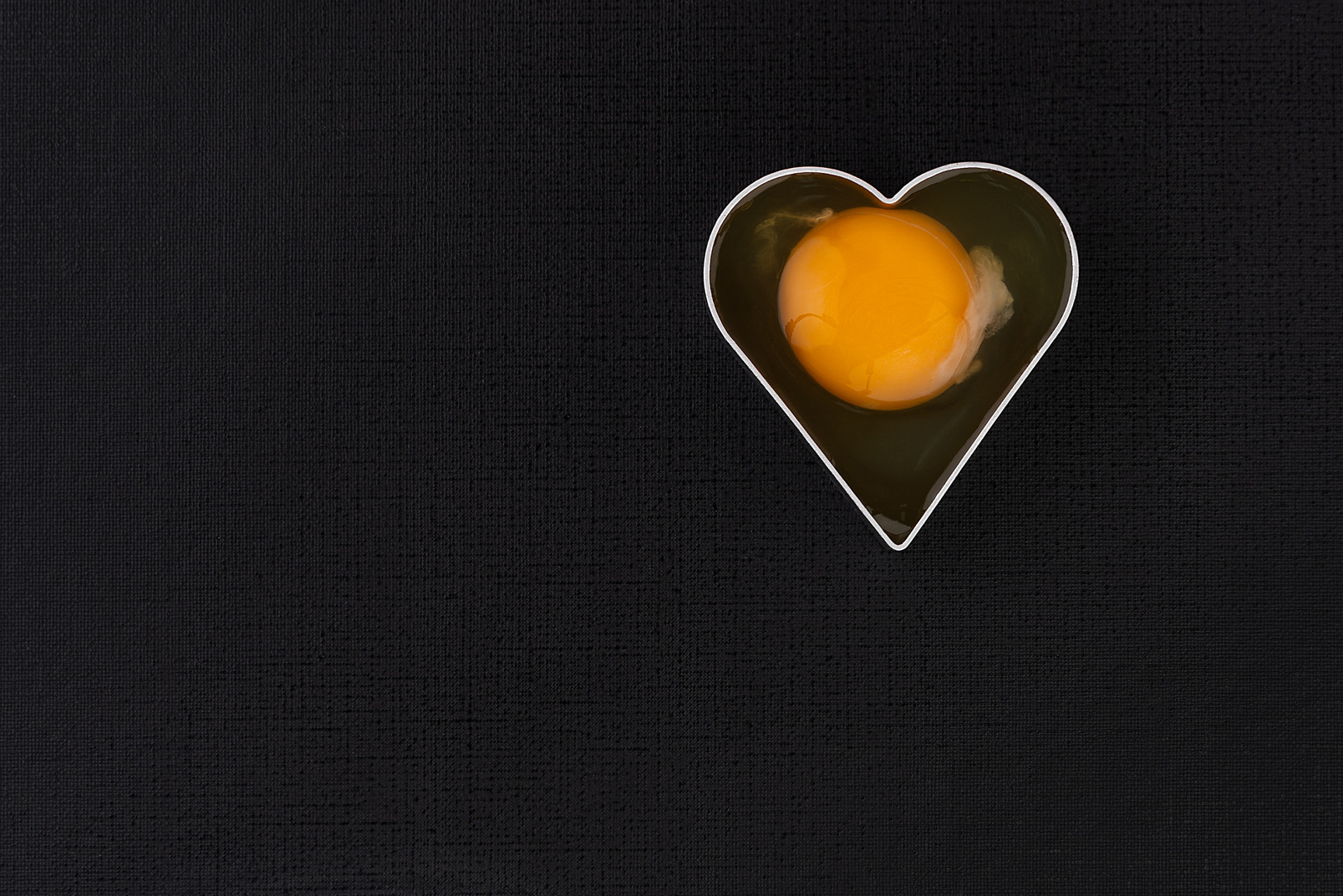 Yellow egg in heart shape cutter