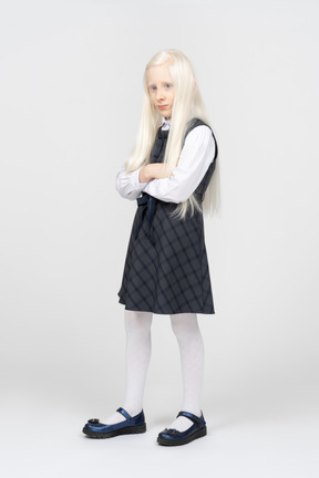 Schoolgirl standing with arms crossed