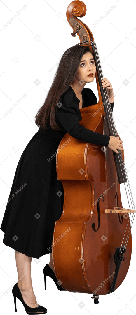 Vista lateral de uma jovem musicista vestida de preto tocando seu contrabaixo