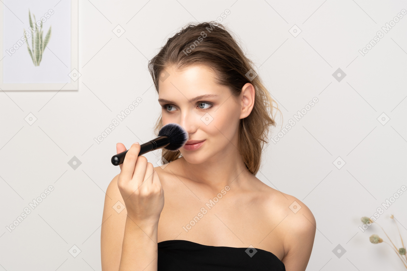 Front view of a young woman applying powder on her nose