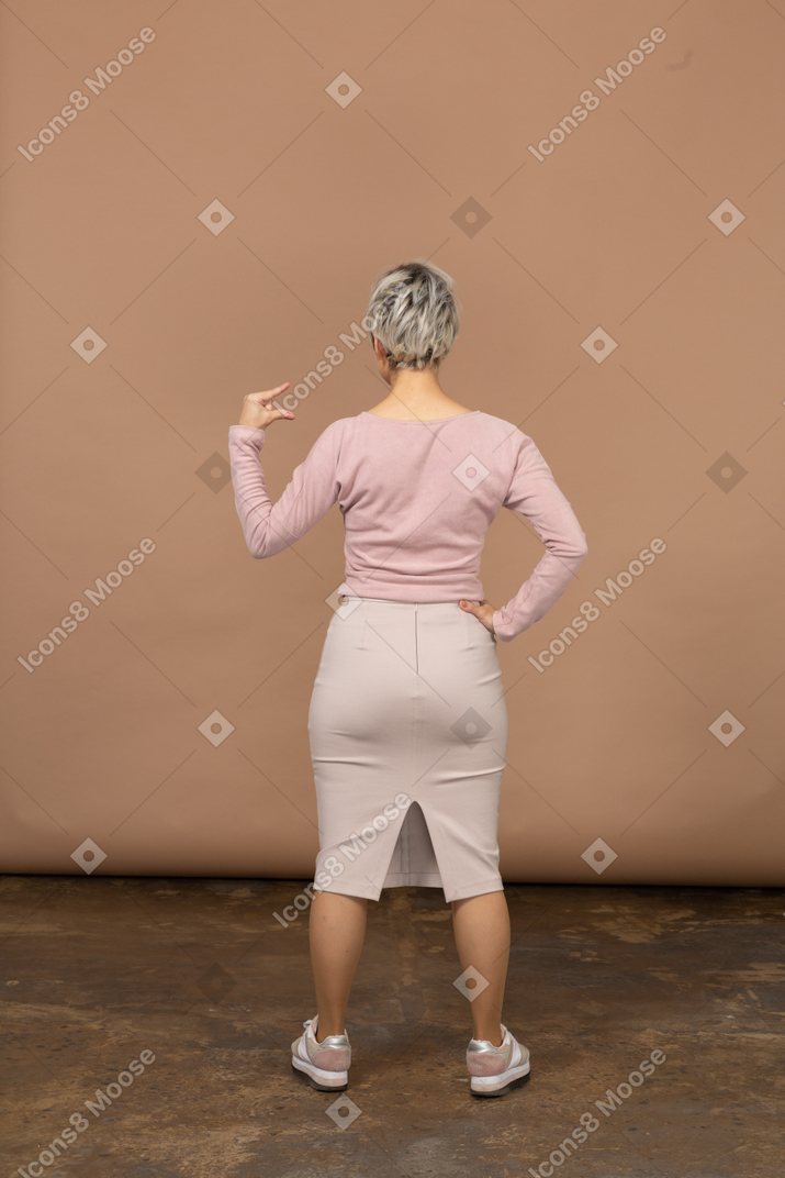 Rear view of a woman in casual clothes showing the small size of something