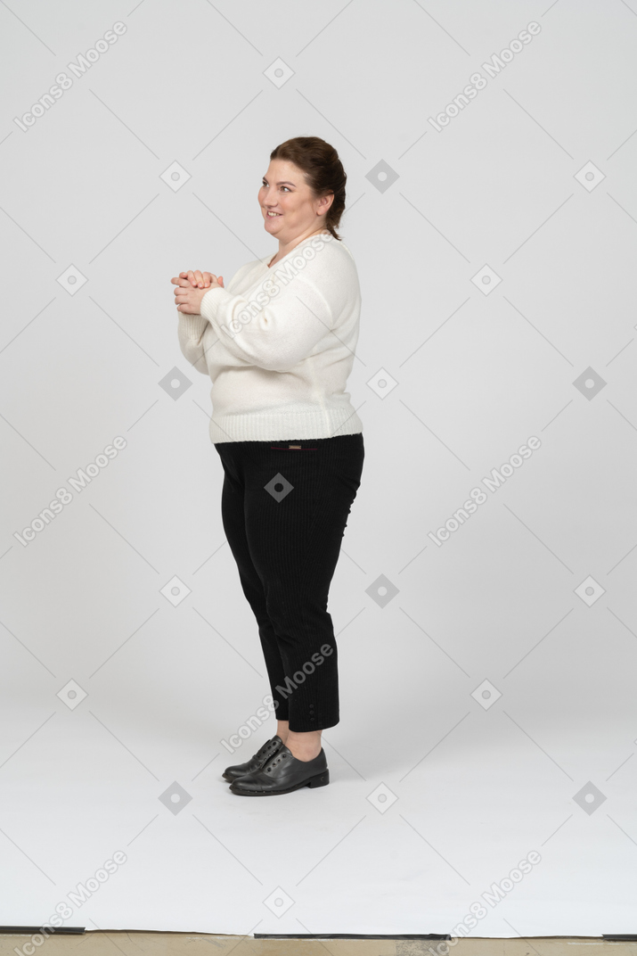 Vista laterale di una donna felice plus size in abiti casual