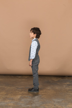프로필에 서 있는 회색 양복에 귀여운 소년