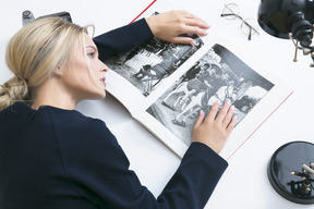 Giovane donna posa sulla scrivania con il libro aperto