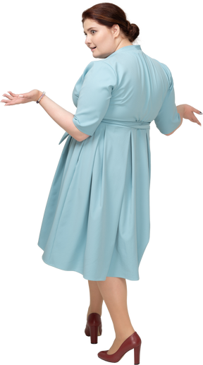 Rear view of a woman in blue dress gesturing