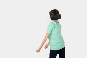 Niño en set de realidad virtual sosteniendo algo invisible detrás de su espalda