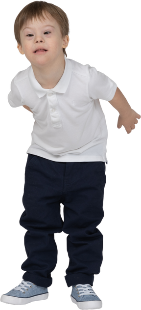 Vista frontal de un niño inclinado hacia adelante con las manos detrás de la espalda