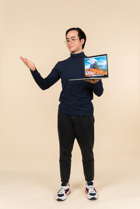 Young asian man presenting a laptop