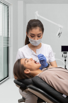A woman is being examined by a dentist in a dental office