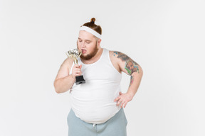 Big guy in sportswear kissing trophy