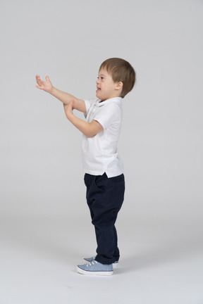 Side view of little boy outstretching his hand