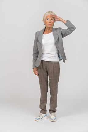 Front view of an old lady in suit looking for someone