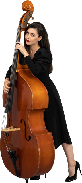 Vue de trois quarts d'une jeune femme musicienne en robe noire tenant sa contrebasse