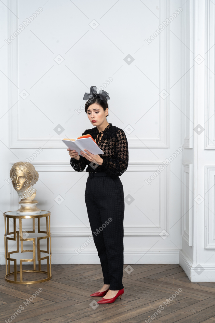 Triste jeune femme lisant un livre