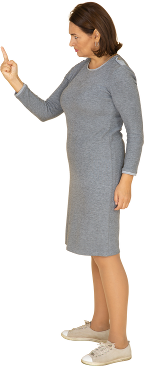 Vue latérale d'une femme en robe grise pointant vers le haut avec un doigt