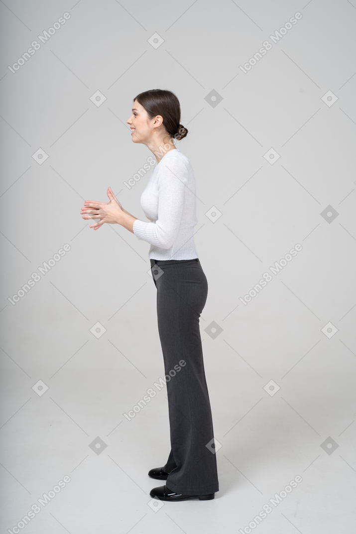 Vue latérale d'une jeune femme en vêtements décontractés faisant des gestes