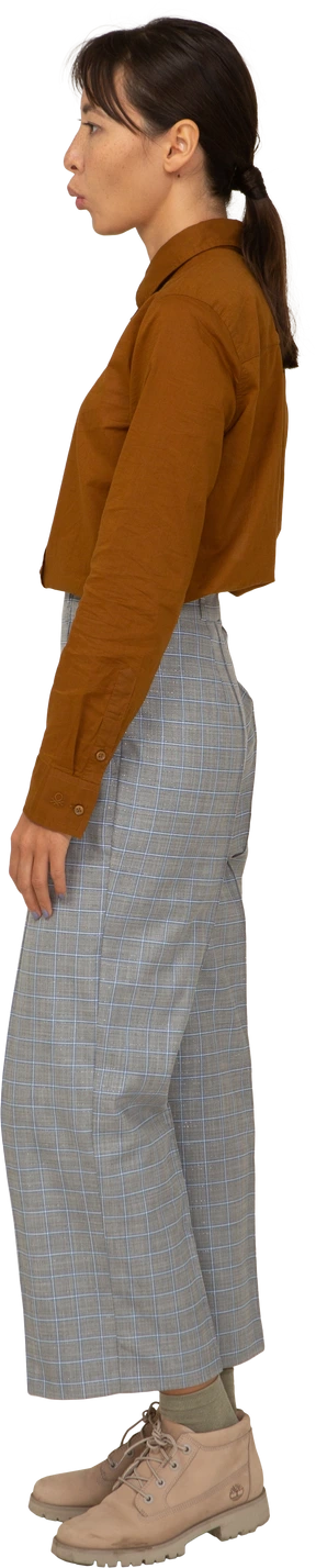 Side view of a naughty pouting young asian female in breeches and blouse