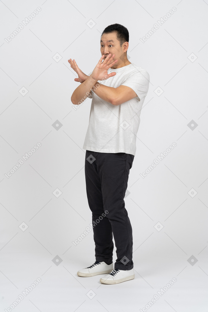 Three-quarter view of scared man showing stop gesture
