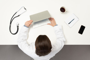 Una doctora abriendo su laptop