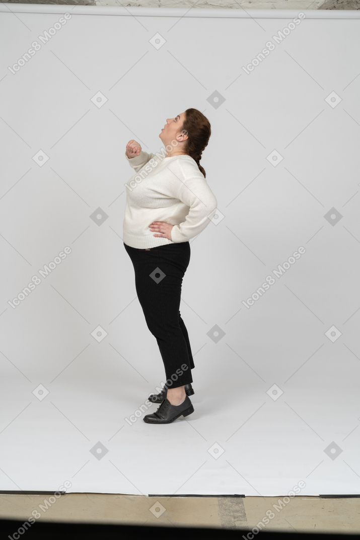 Side view of a plump woman in casual clothes looking up