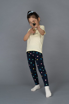 Ritratto di una bambina che punta un fucile