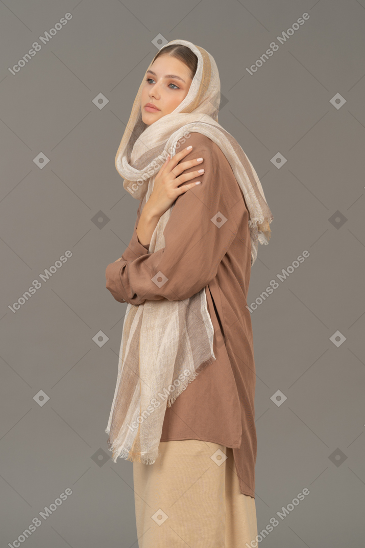 Vista lateral de uma mulher em roupas tradicionais, olhando de soslaio