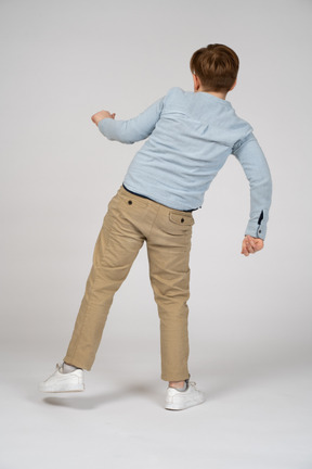 Back view of a young boy leaning to the side