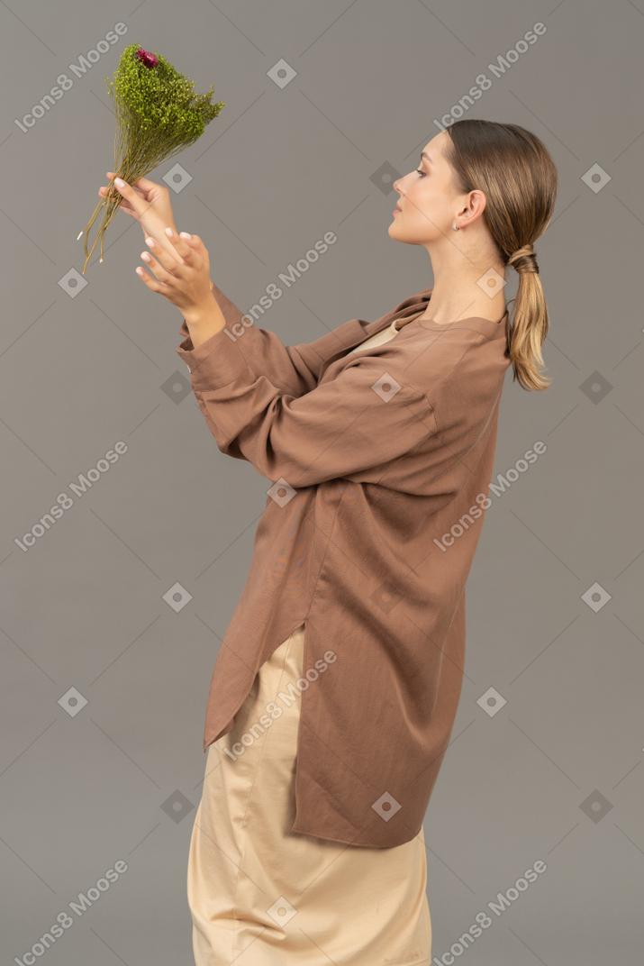 Вид сбоку на женщину с букетом