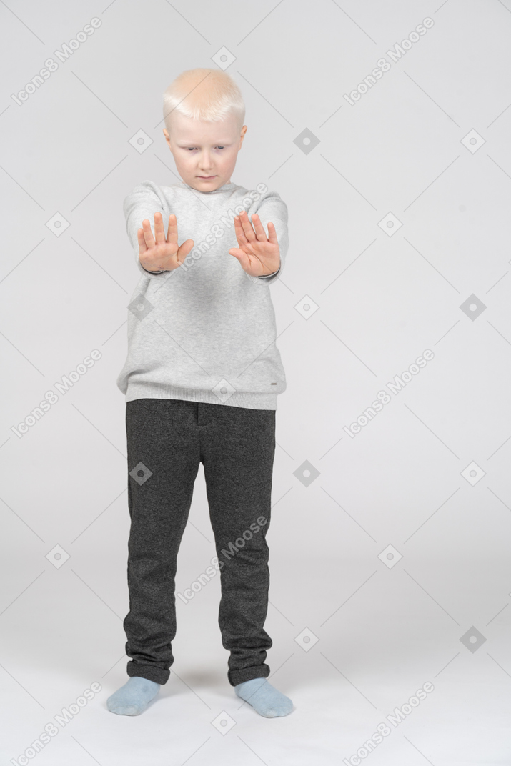 Petit garçon avec les deux bras tendus