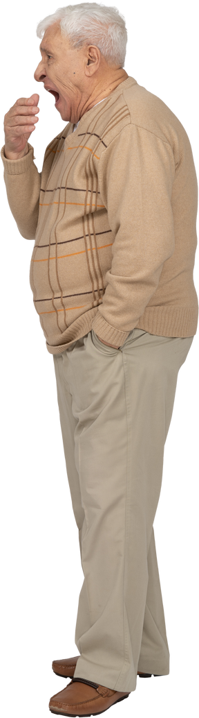 Vista lateral de un anciano con ropa informal bostezando