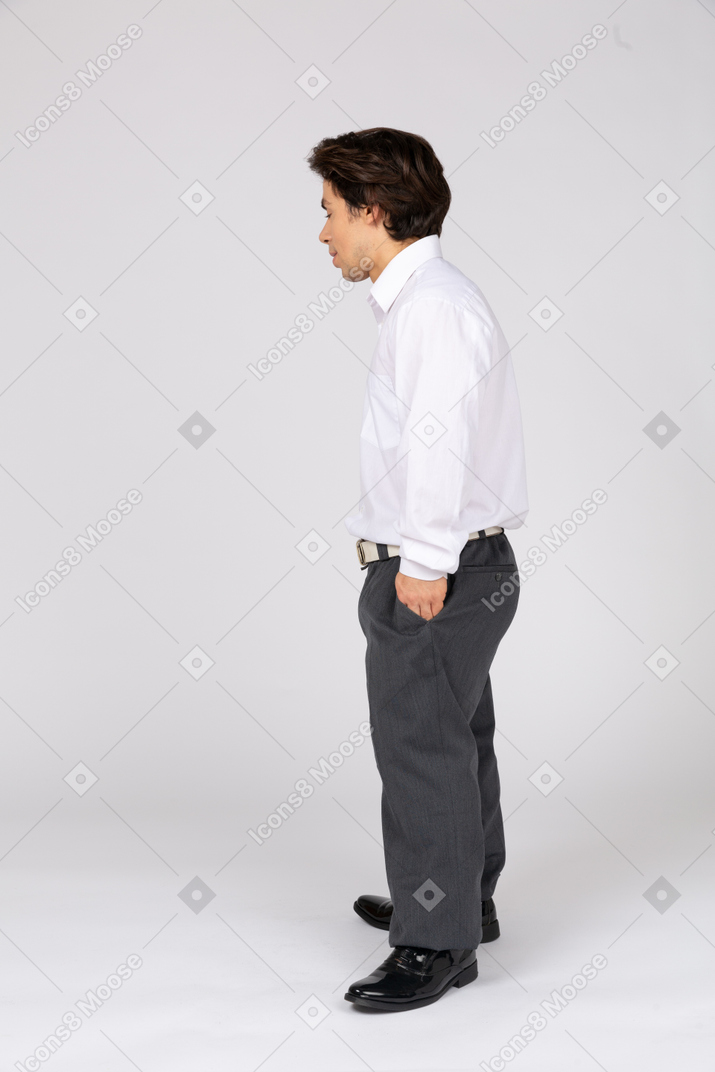 Вид сбоку молодого человека с рукой в кармане
