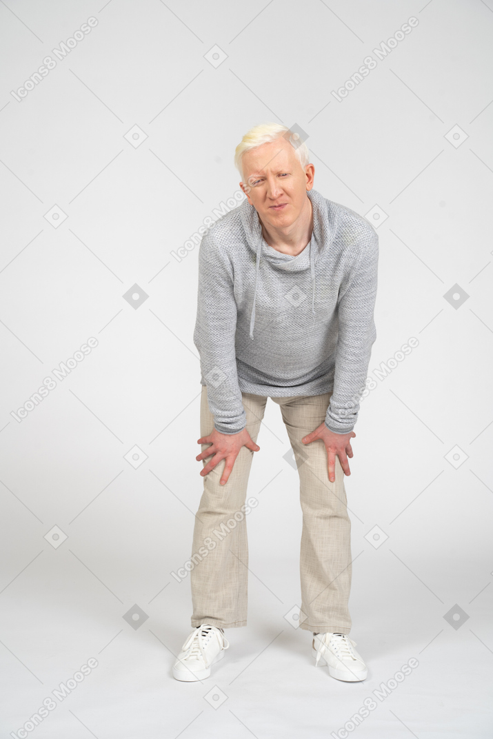 Front view of a man touching knees