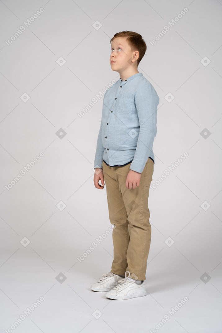 Boy standing in profile and looking up