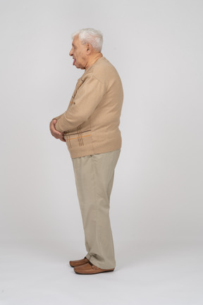 舌を示すカジュアルな服装の老人の側面図