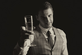 Atractivo joven caballero levantando una copa de champán